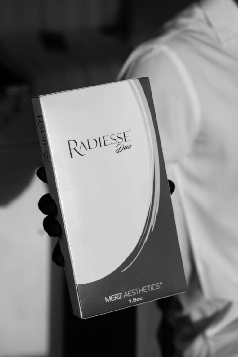 Black and white close-up of Radiesse Duo packaging held by a gloved hand, adds elegance.